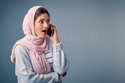 Buy stock photo Surprised, phone call and muslim woman with smartphone in studio for shock, wow or omg reaction on blue background. Hijab, amazed and Arab person with wtf expression for gossip, fake news or secret