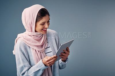 Buy stock photo Muslim, woman and reading online with tablet, ebook or streaming video to watch on web. Contact, communication and girl relax with mobile app or chat on internet in studio background or mockup space