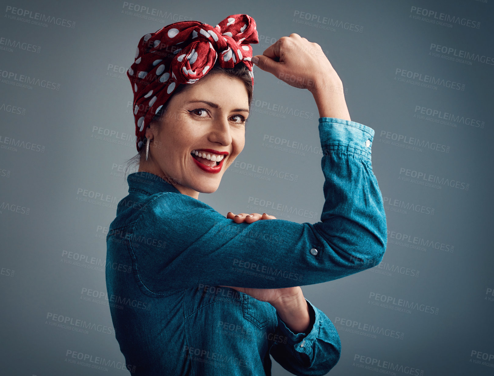 Buy stock photo Pinup girl, strong and flexing muscle portrait in studio for beauty, women power and fashion. Happy female person show bicep on a grey background for motivation, freedom and retro or vintage style