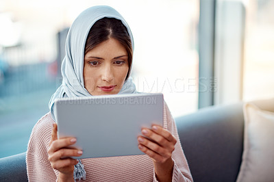 Buy stock photo Relax, tablet and muslim woman on sofa in living room streaming movie, film or show for entertainment at home. Rest, digital technology and islamic female person watching video online at apartment.