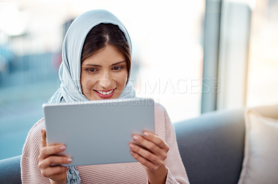 Buy stock photo Smile, tablet and muslim woman on sofa in living room streaming movie, film or show for entertainment at home. Rest, digital technology and islamic female person watching video online at apartment.