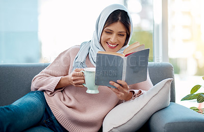 Buy stock photo Smile, reading and muslim woman with coffee and book on sofa relaxing in living room at home. Happy, cappuccino and islamic female person enjoying literature, novel or story on couch at apartment.