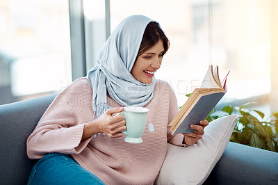 Buy stock photo Relax, reading and muslim woman with coffee and book on sofa in living room at home. Smile, cappuccino and islamic female person resting and enjoying literature, novel or story on couch at apartment.
