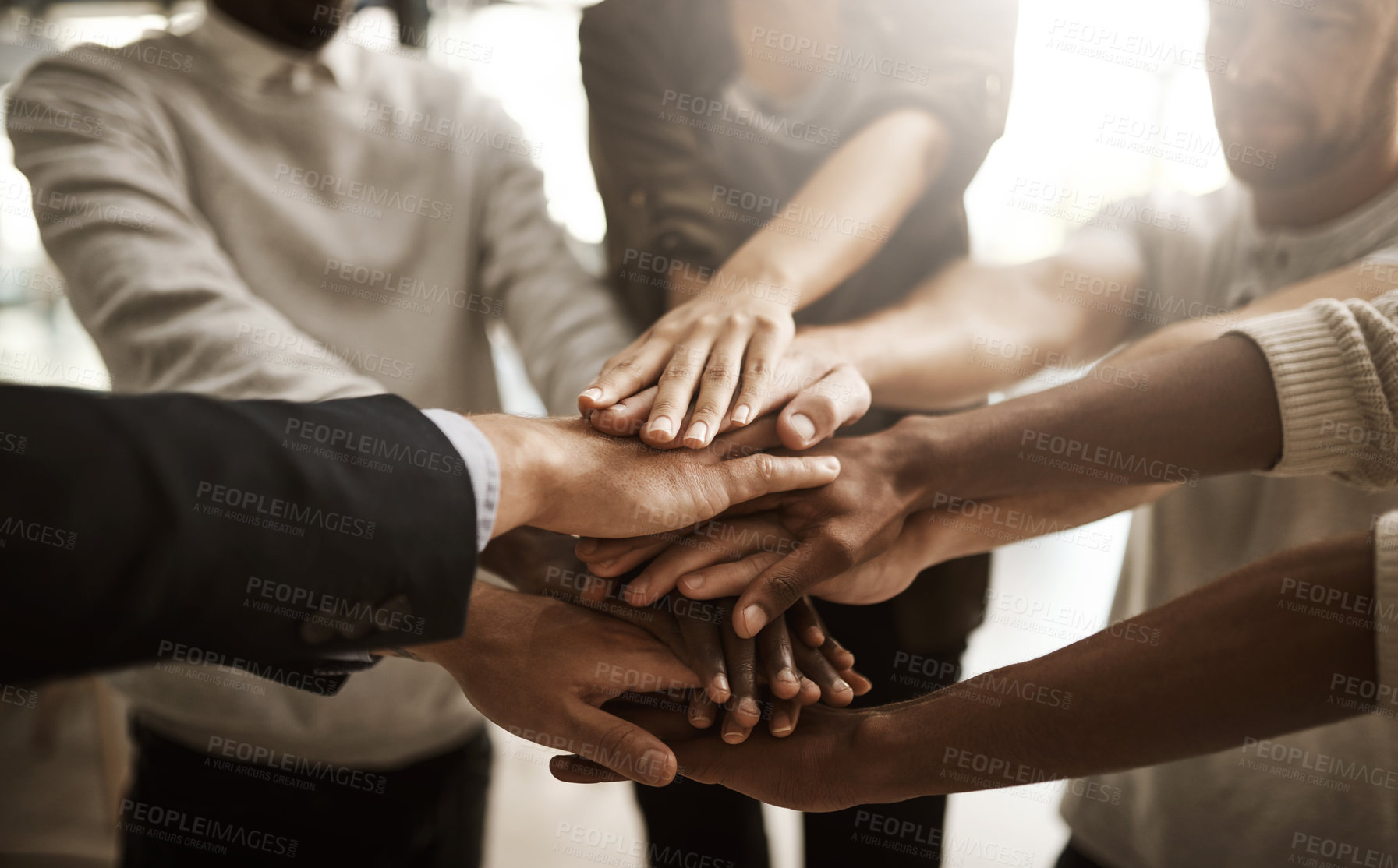 Buy stock photo Businesspeople with their hands together in a huddle pile showing support, teamwork and close collaboration at the workplace. Closeup of a diverse group of colleagues standing in unity at the office