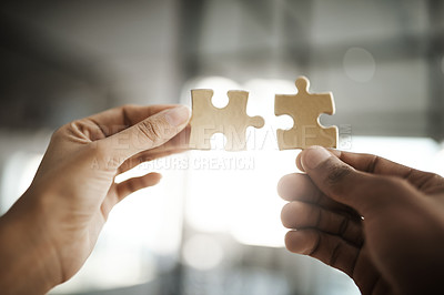 Buy stock photo Teamwork, unity and growth with puzzle pieces in the hands of business people building, growing and working together as a team. Closeup of colleagues showing togetherness and synergy from below