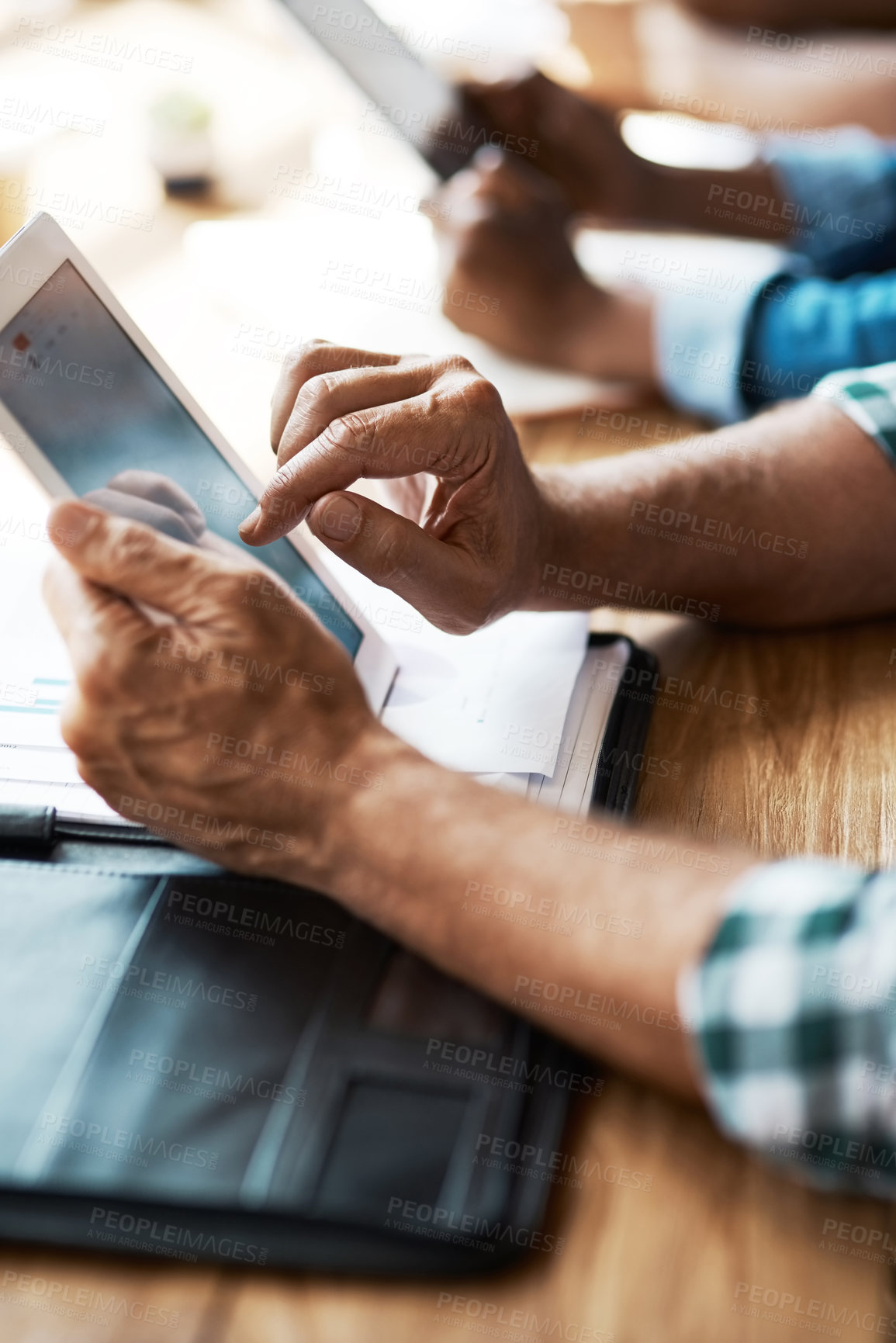 Buy stock photo Cropped shot of a businessman using a digital tablet during a boardroom meeting