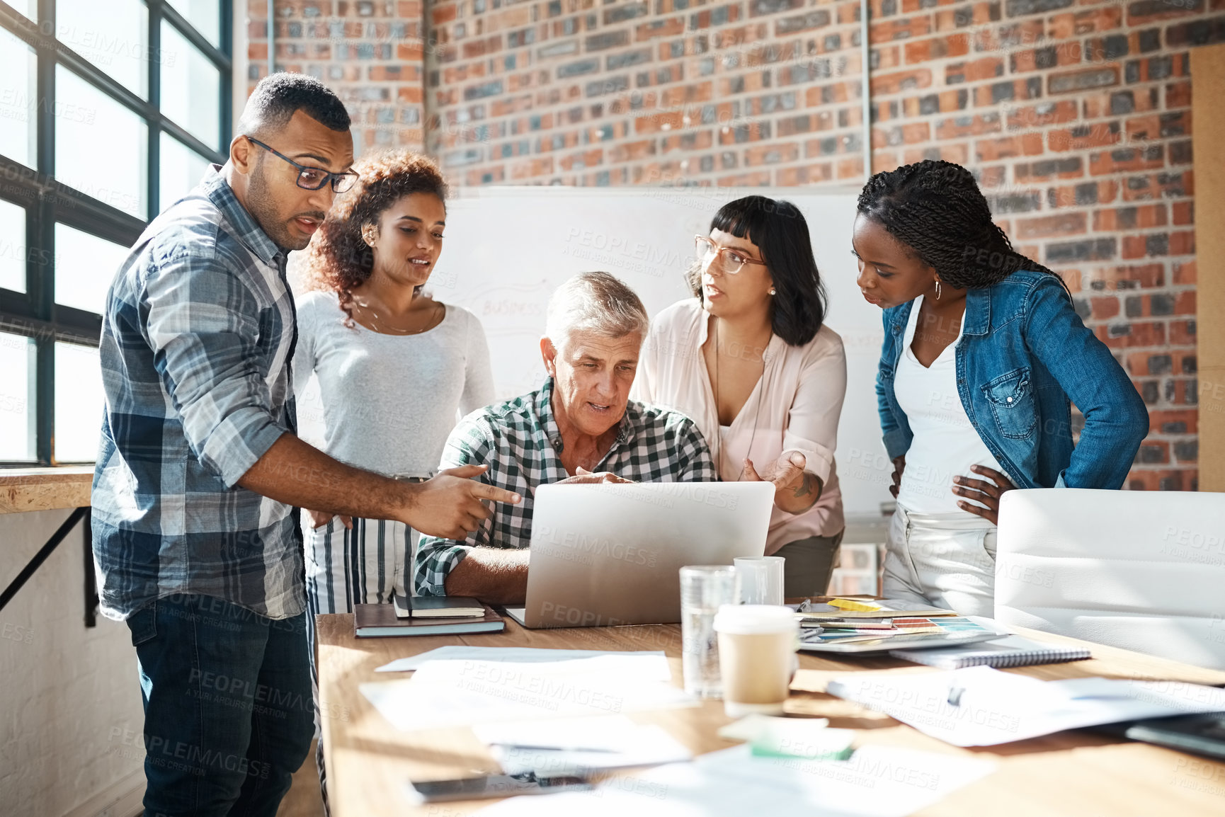 Buy stock photo Reading, teamwork and group in meeting with laptop, creative and listening to speaker, pointing or explaining. Boardroom, interior designer and people with discussion for project, planning or talking