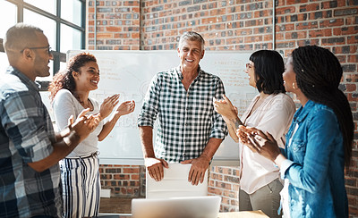 Buy stock photo Shot of a mature businessman being applauded by his colleagues during a meeting