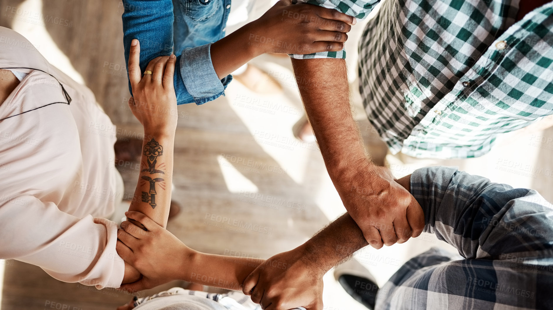 Buy stock photo High angle shot of a group of unidentifiable businesspeople holding on to each other's arms