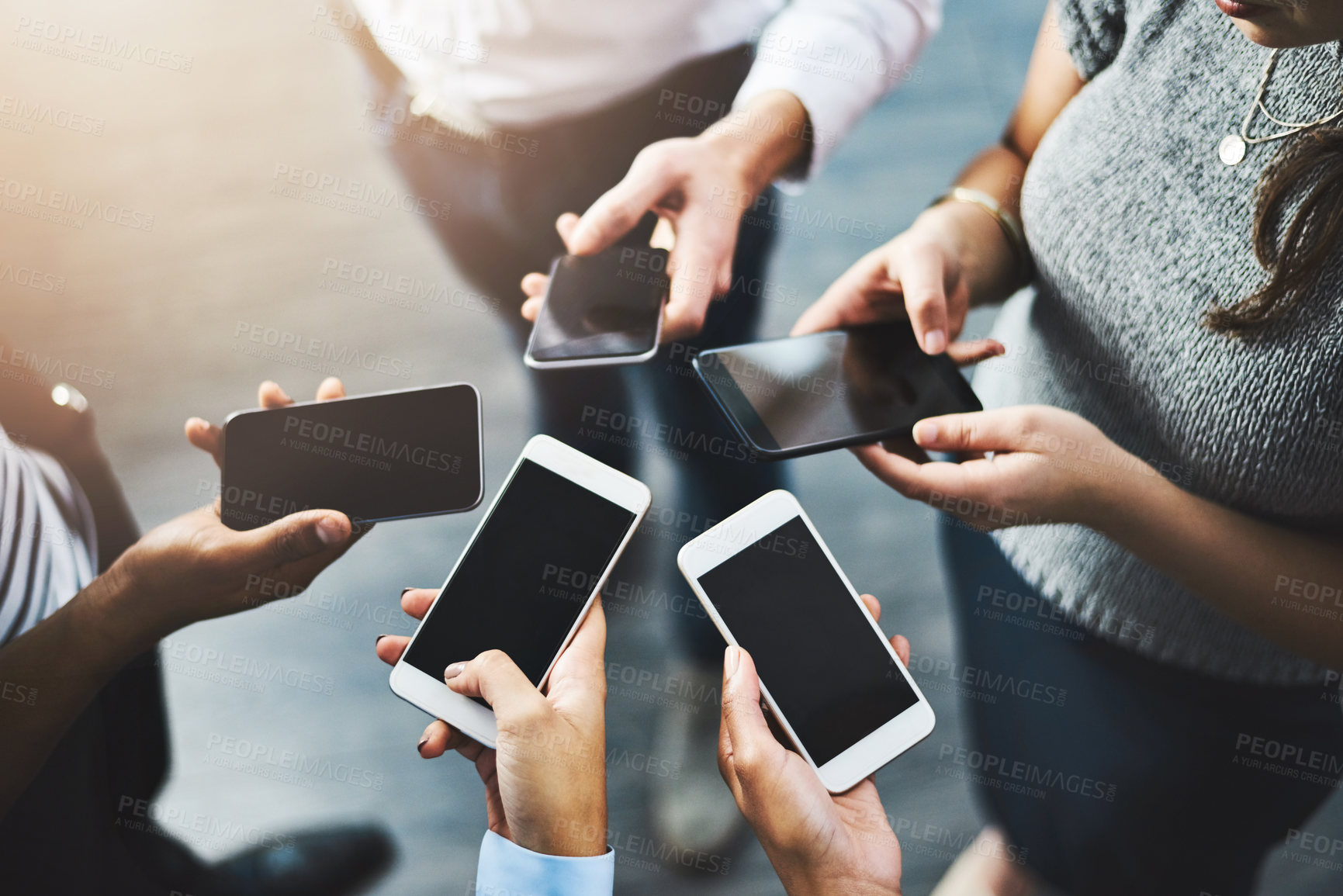 Buy stock photo Closeup shot of a group of businesspeople using their cellphones in synchronicity