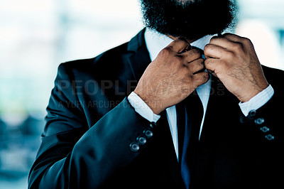 Buy stock photo Shot of an unrecognizable businessman adjusting his tie in the office during the day