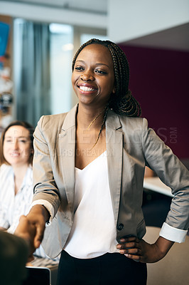Buy stock photo Shot of a cheerful young businesswoman shaking hands with a work colleague after a meeting in the office at work during the day