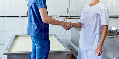 Buy stock photo Cropped shot of two people shaking hands in a cheese factory