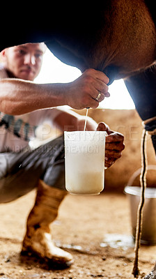 Buy stock photo Cropped shot of a male farmer milking a cow