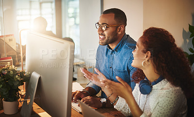 Buy stock photo Shot of a young businessman and businesswoman using a computer together during a late night at work