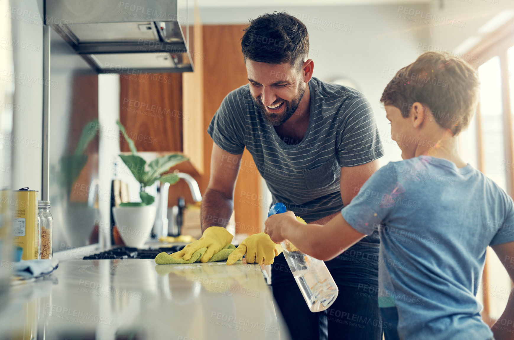 Buy stock photo Shot of a father and son cleaning the kitchen counter together at home