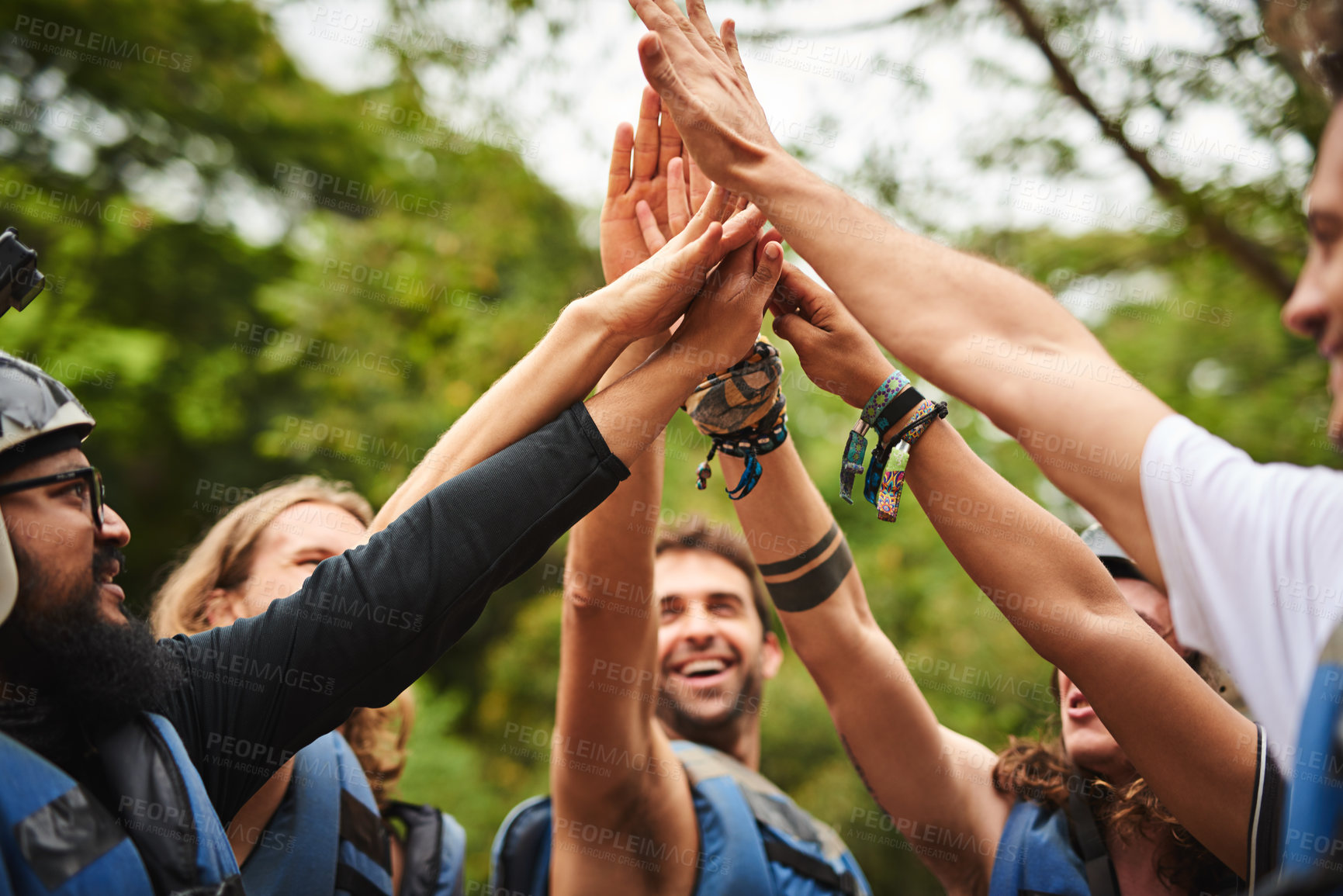 Buy stock photo Cropped shot of a group of young friends high fiving while out white water rafting
