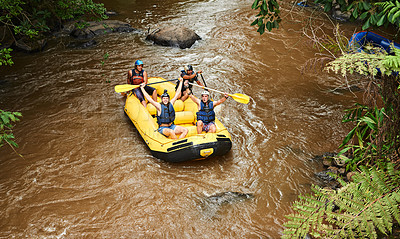 Buy stock photo High angle shot of a group of young friends cheering while white water rafting