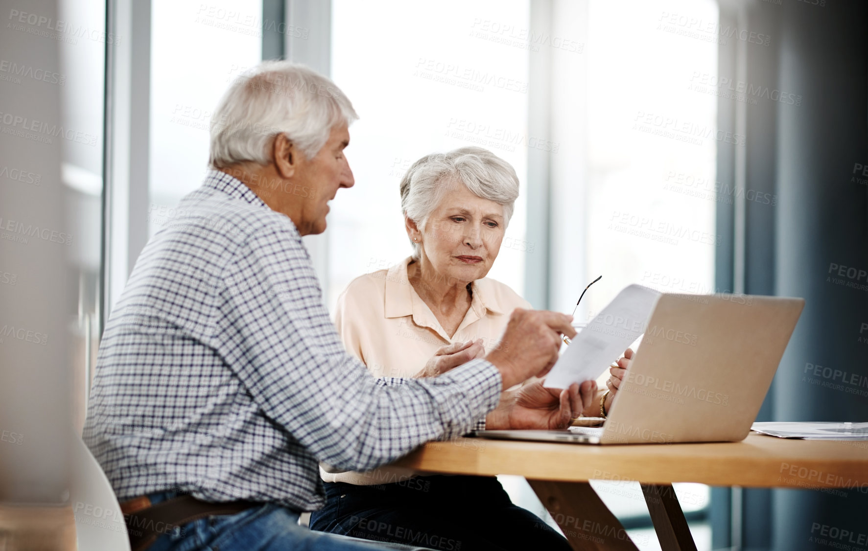 Buy stock photo Cropped shot of a senior couple working on their finances at home