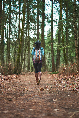 Buy stock photo Rearview shot of an unrecognizable woman walking in the woods