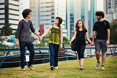 Buy stock photo Shot of young college couples holding hands and walking outside