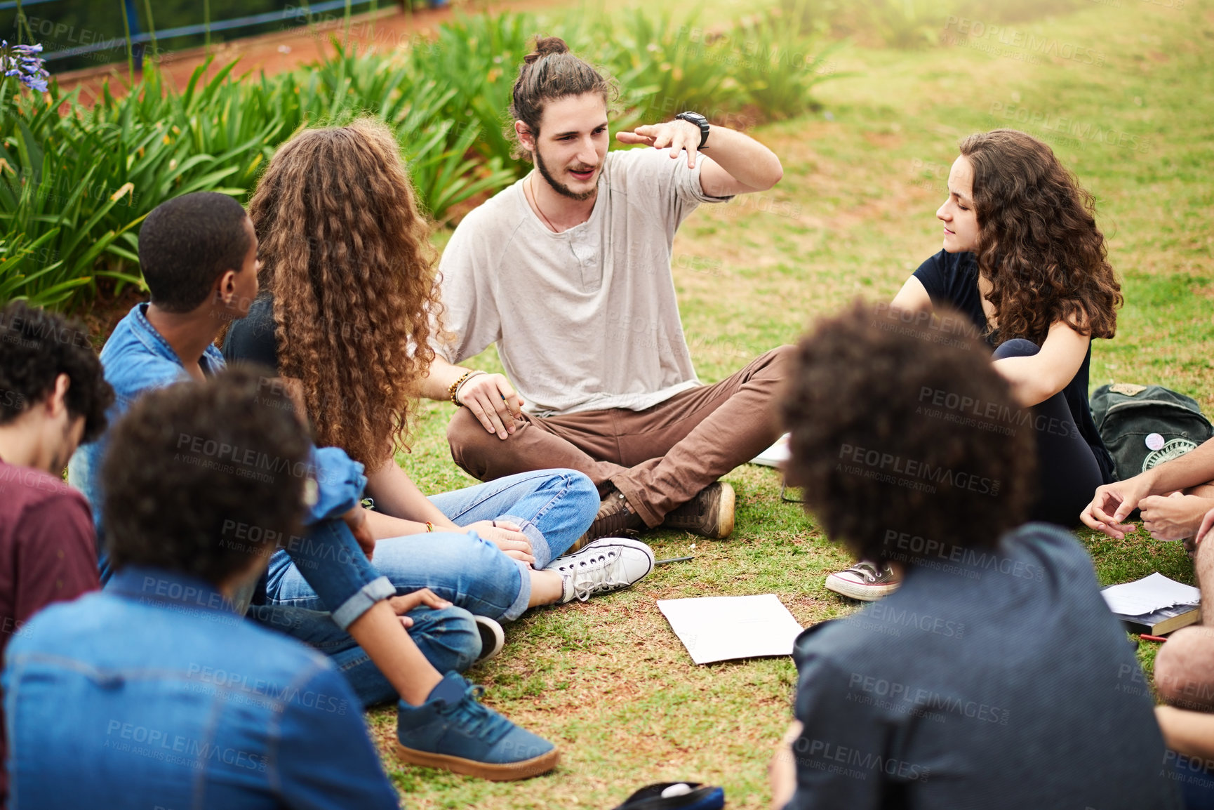 Buy stock photo Cropped shot of a group of college students having a discussion while sitting in a circle outside