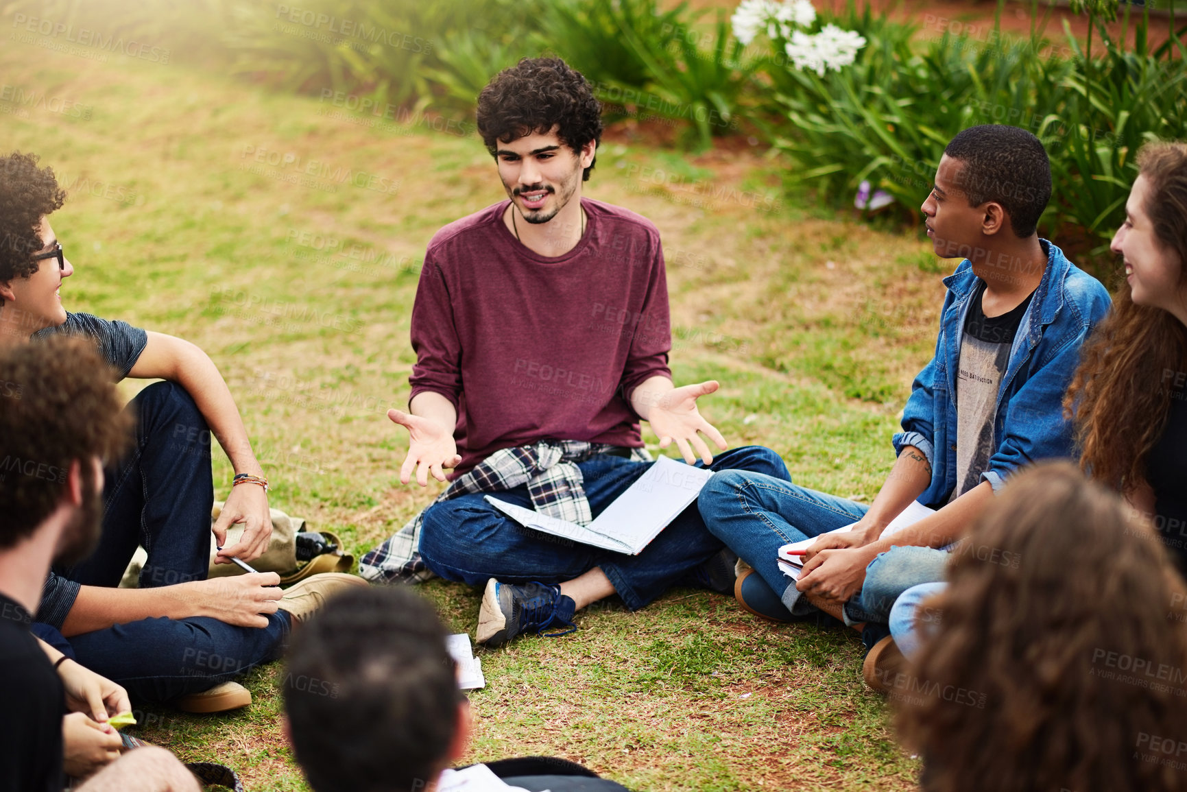 Buy stock photo Cropped shot of a group of college students having a discussion while sitting in a circle outside