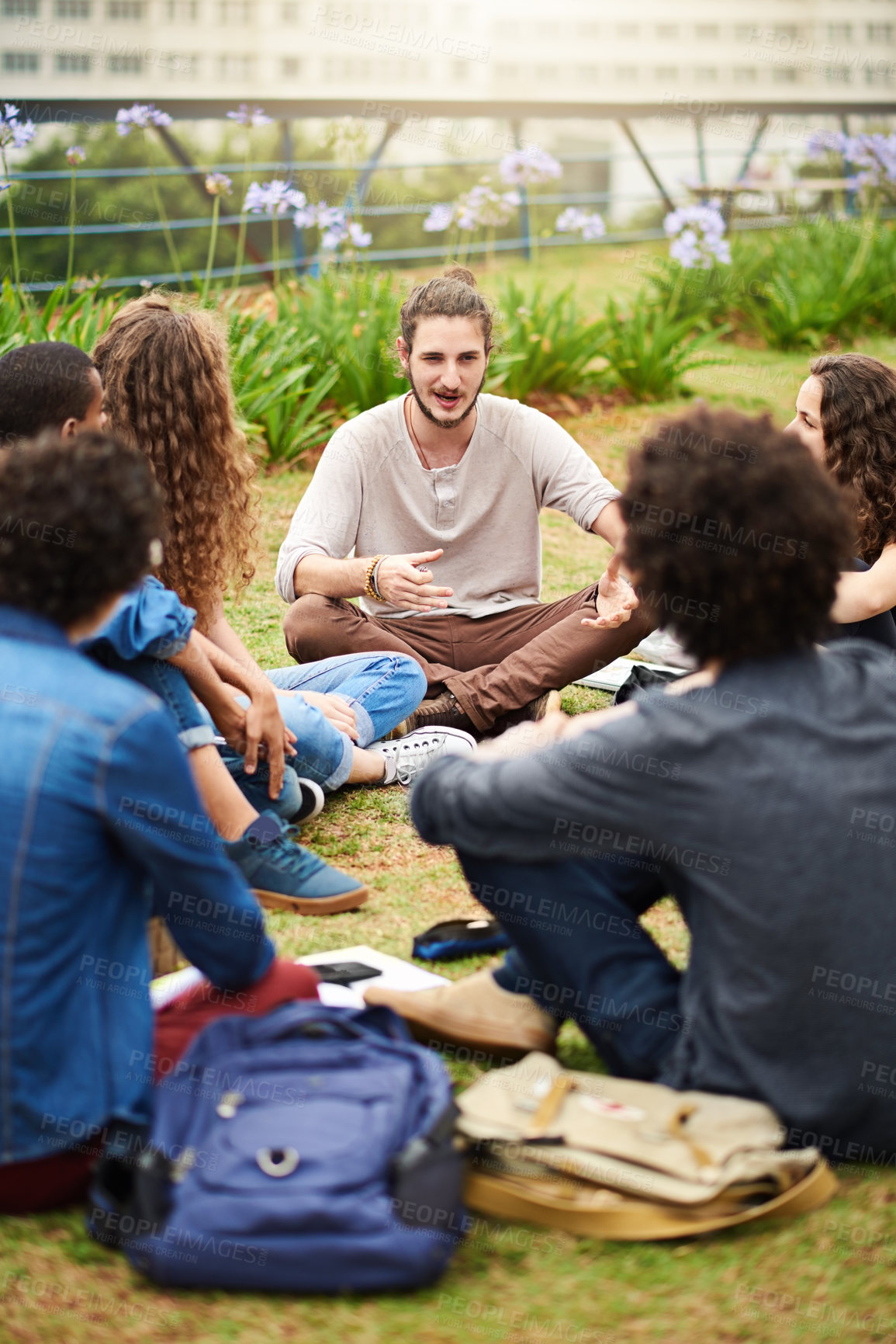 Buy stock photo Cropped shot of a group of college students having a discussion while sitting in a circle outside