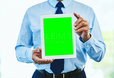 Buy stock photo Shot of an unrecognizable mature man holding up a digital tablet in front of him with the screen facing the camera inside of a building during the day