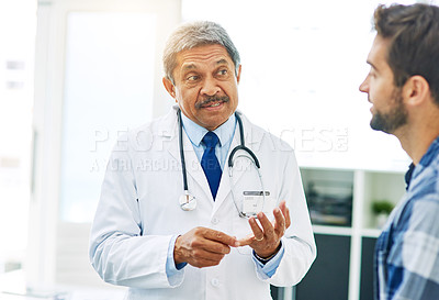 Buy stock photo Matured doctor, consultation and man for healthcare with patient, conversation and diagnosis in clinic. Hospital, help and communication for medicine and sick person, professional and medical results