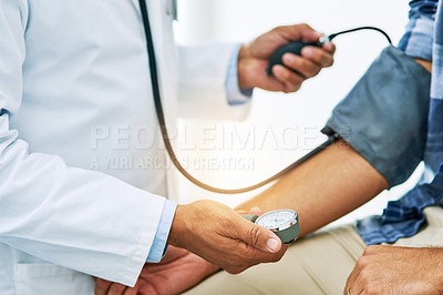 Buy stock photo Shot of an unrecognizable male doctor running tests on a patient inside of a examination room during the day