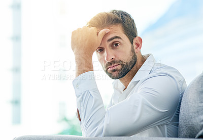 Buy stock photo Portrait of a young carefree man seated on a sofa while contemplating during the day