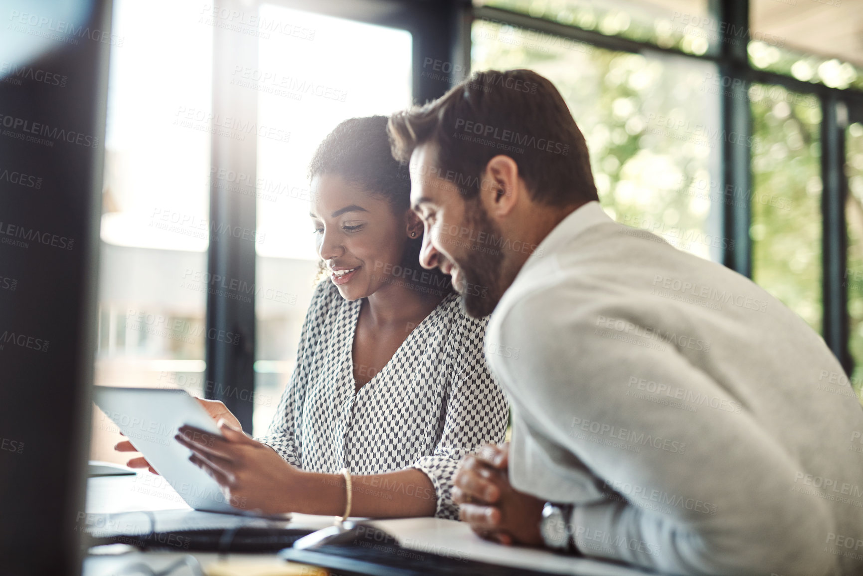 Buy stock photo Shot of two businesspeople discussing something on a digital tablet