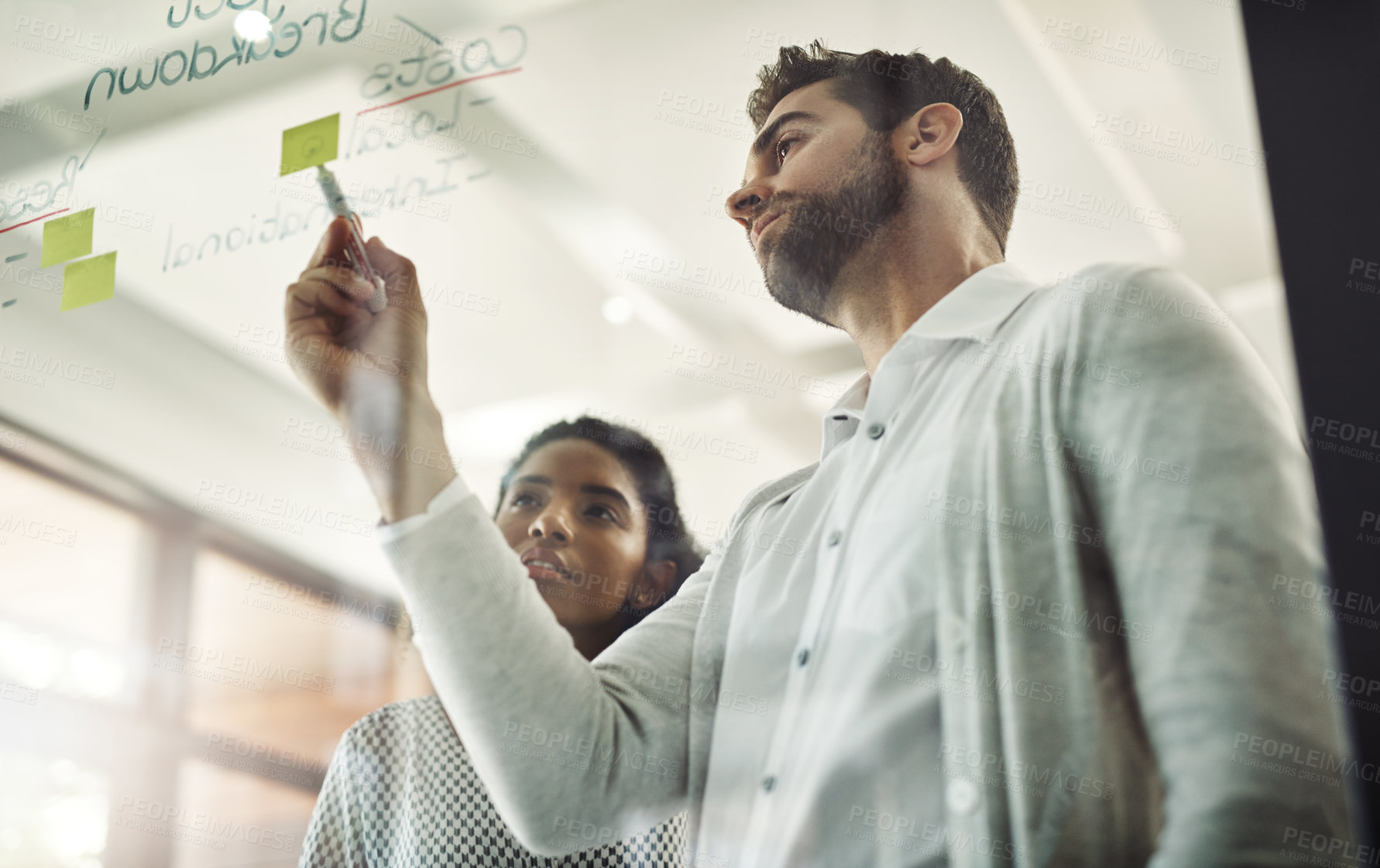 Buy stock photo Man, woman and writing on glass at office with sticky note, planning and teamwork with budget at creative agency. Business people, partnership and low angle by board with mindmap, cost and finance