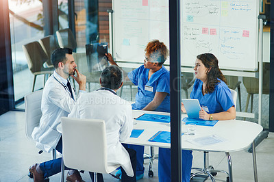 Buy stock photo Shot of a group of medical practitioners analyzing x-rays in a hospital
