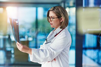 Buy stock photo Shot of a doctor analyzing an x-ray in a hospital