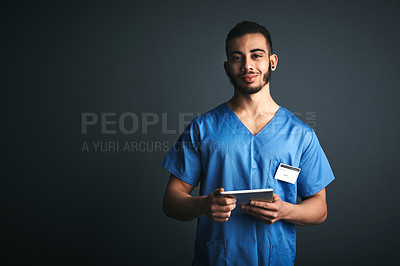 Buy stock photo Studio shot of a young doctor using a digital tablet against a gray background