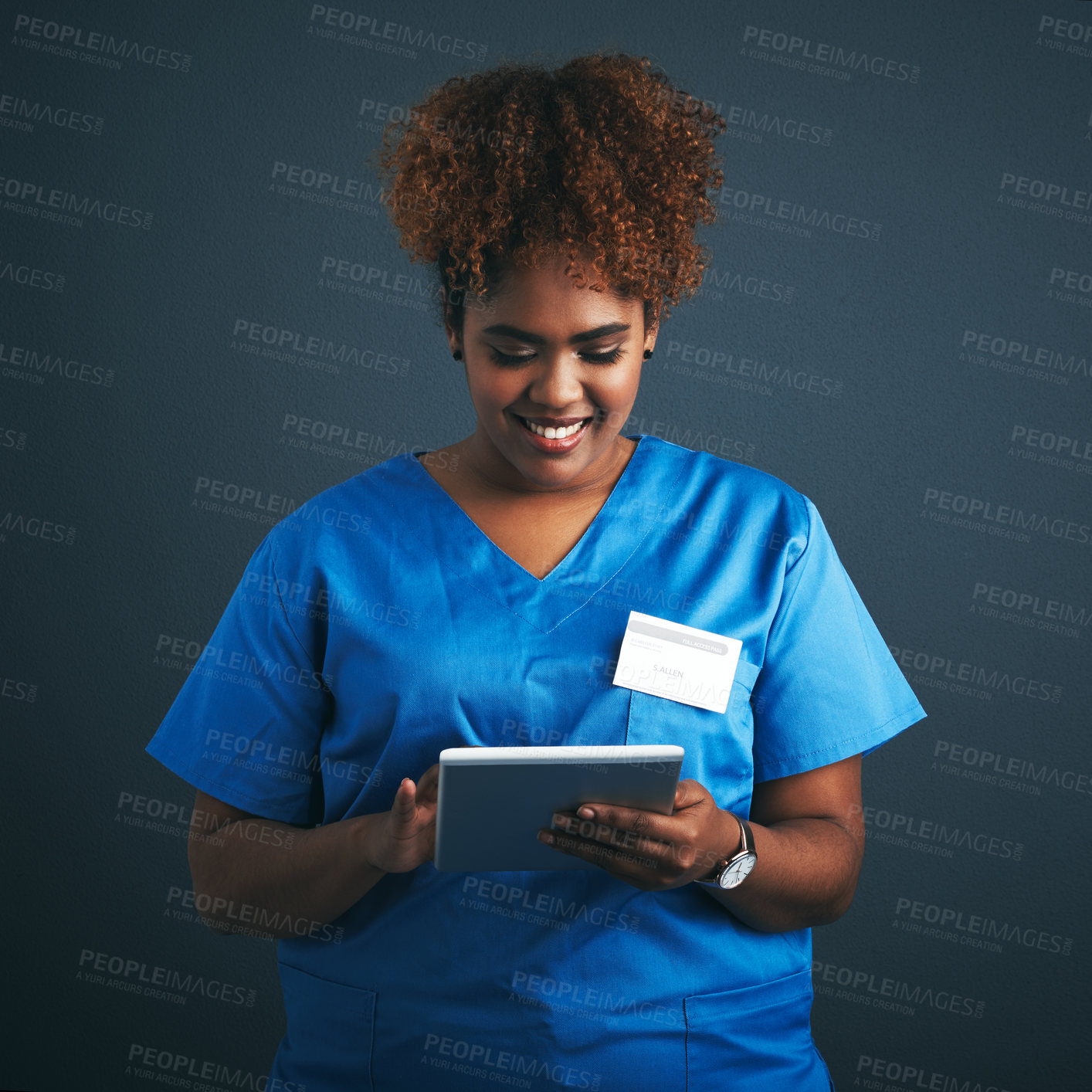 Buy stock photo Studio shot of a young doctor using a digital tablet against a gray background