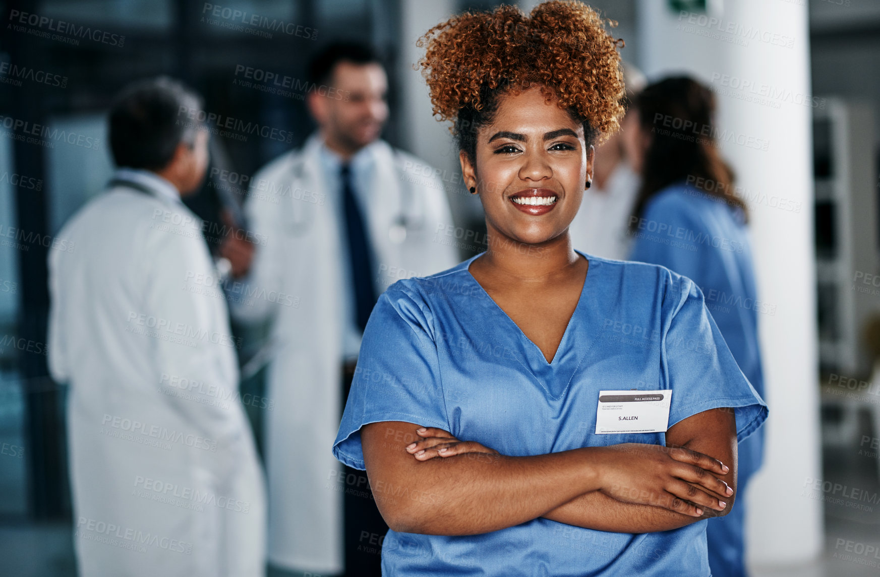 Buy stock photo Portrait of a confident young doctor working in a hospital with her colleagues in the background