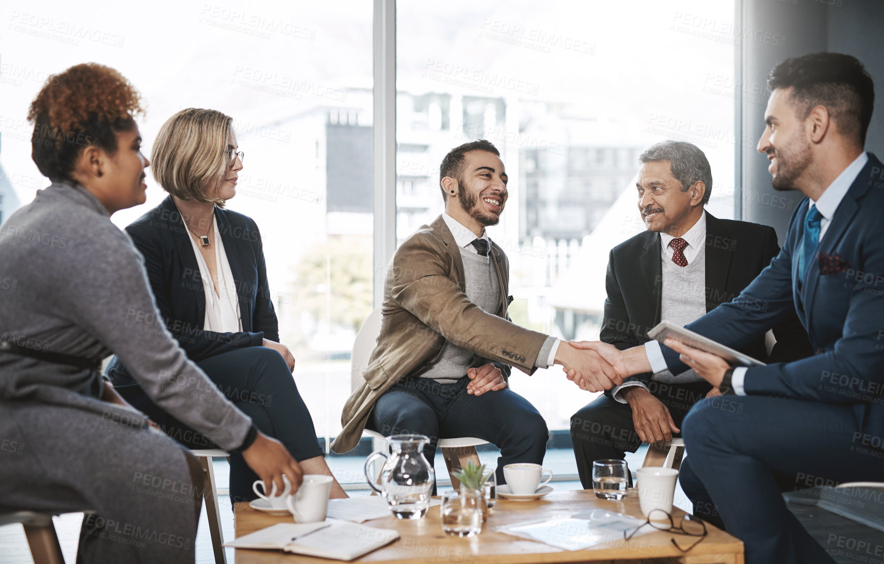 Buy stock photo Shot of businesspeople shaking hands during a meeting in an office