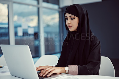 Buy stock photo Cropped shot of an attractive young arabic businesswoman working on her laptop in the office