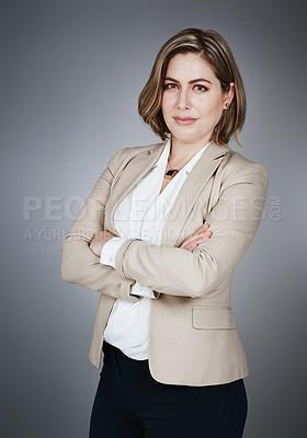 Buy stock photo Studio portrait of a confident young businesswoman posing against a gray background