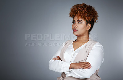 Buy stock photo Studio shot of a confident young businesswoman looking thoughtful against a gray background