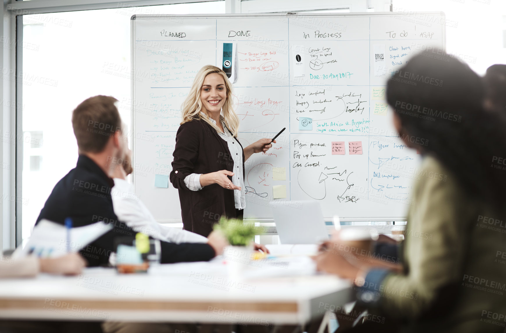 Buy stock photo Shot of a businesswoman giving a presentation to her colleagues on a whiteboard in a boardroom