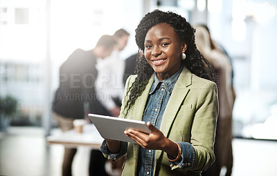 Buy stock photo Portrait of a young businesswoman using a digital tablet in an office with her colleagues in the background