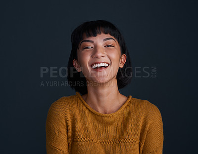 Buy stock photo Studio shot of an attractive young woman posing against a dark background