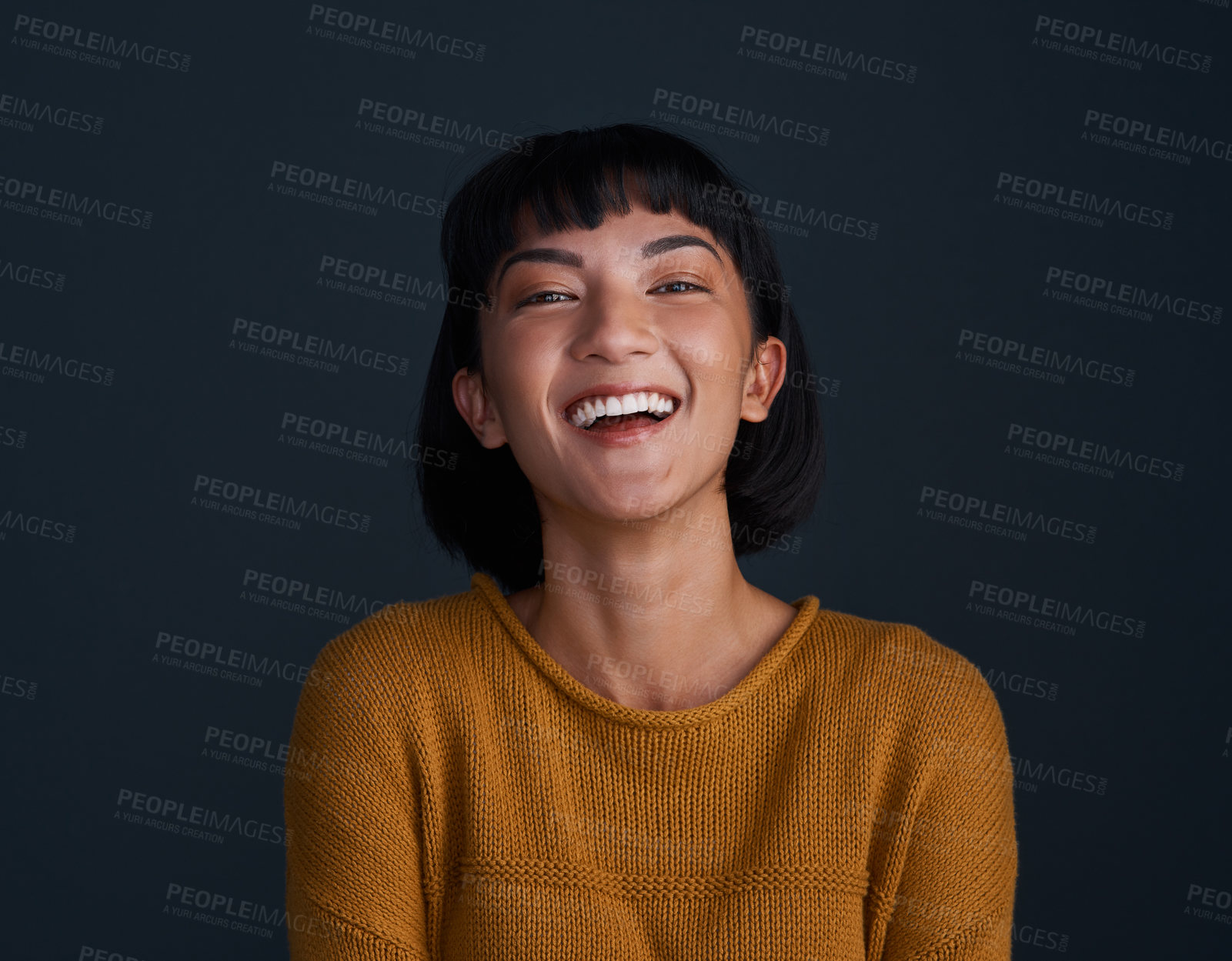 Buy stock photo Studio shot of an attractive young woman posing against a dark background