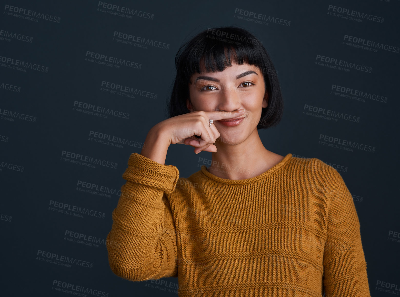 Buy stock photo Portrait, Asian woman and finger with mustache in studio for comedy, quirky and funny. Female person, photo booth and funky on black background with expression, smile and casual fashion in Vietnam