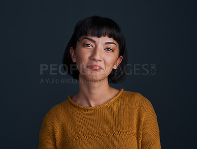 Buy stock photo Studio shot of an attractive young woman pouting against a dark background