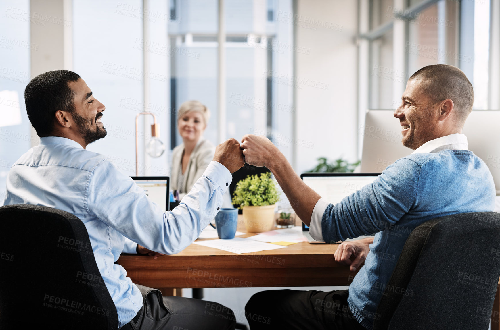 Buy stock photo Rearview shot of two businessmen fist pumping in an office